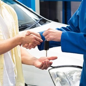 Customer shaking hands with mechanic taking keys at the repair g антикоррозийная обработка автомобиля в барнауле